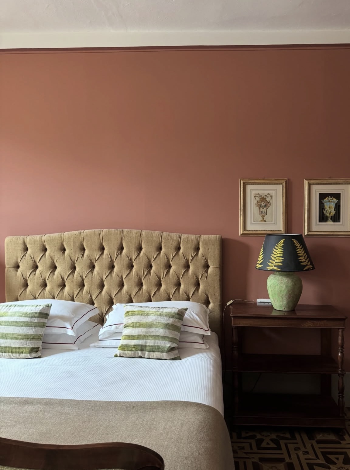 Guest bedroom with a tufted headboard and terracotta walls