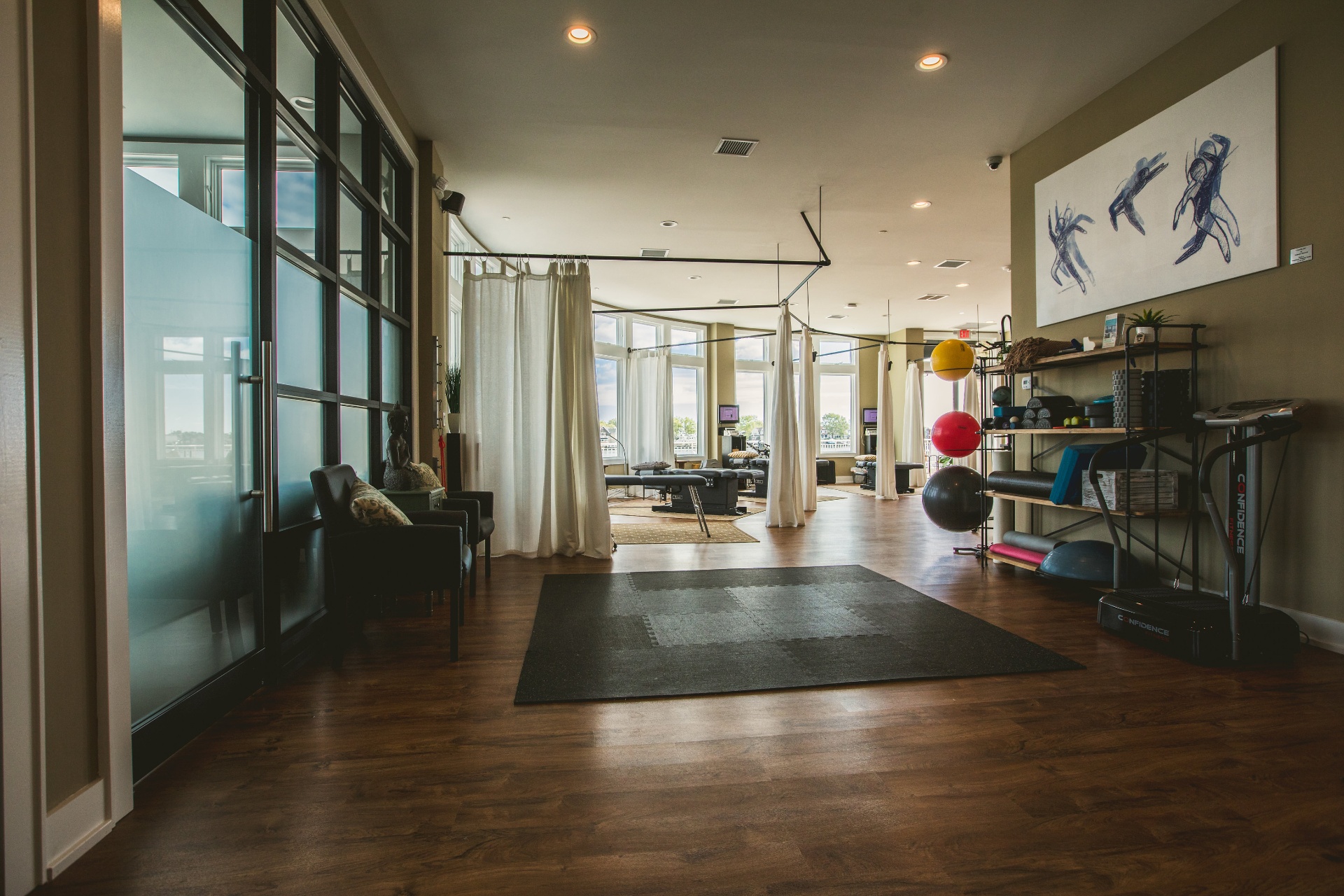 Entry into the IWG Belmar movement studio — bayfront windows, adjusting suites in the background